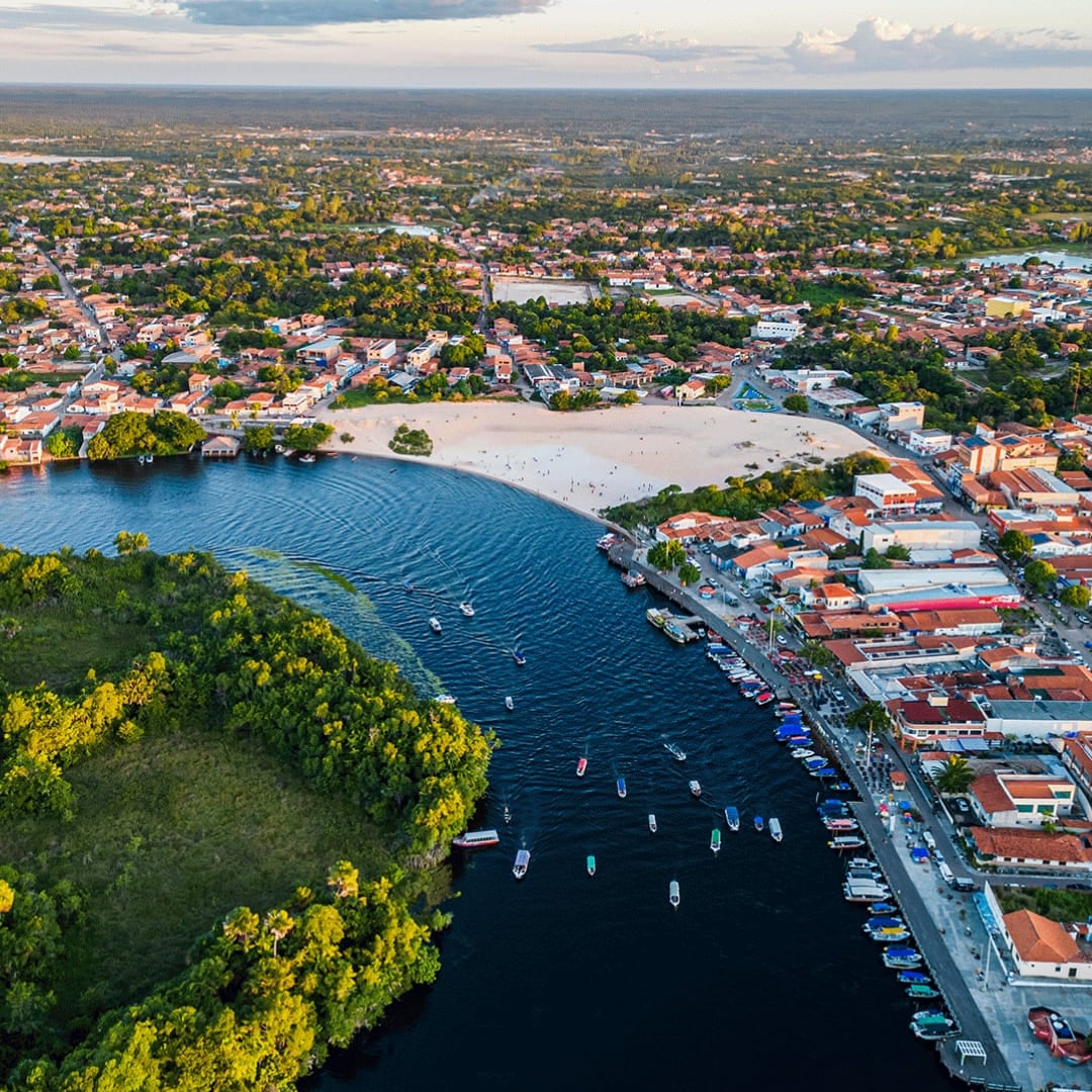 Aerial view of Barreirinhas town focusing on the Preguiças River bend and sandy stretches, illustrating the main park entrance.