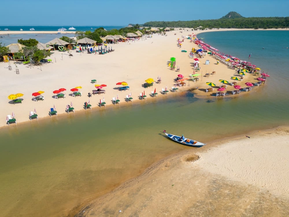 White sand beach of Ilha do Amor stretching into the clear waters of the Tapajós River in Alter do Chão.