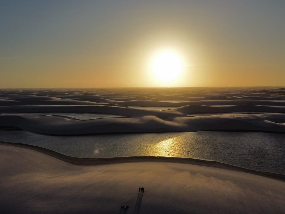 The sun sets brightly over the undulating white sand dunes and rainwater lagoons in the national park. The sun sets brightly over the undulating white sand dunes and rainwater lagoons in the national park.