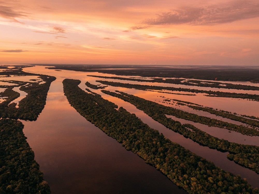 Aerial view of the dark waters of the Negro River and forested islands of Anavilhanas National Park at sunset. Aerial view of the dark waters of the Negro River and forested islands of Anavilhanas National Park at sunset.