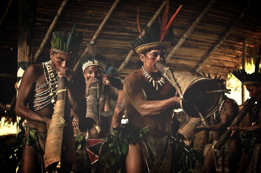 Indigenous people from the Amazon playing traditional wind instruments during a cultural presentation. Indigenous people from the Amazon playing traditional wind instruments during a cultural presentation.