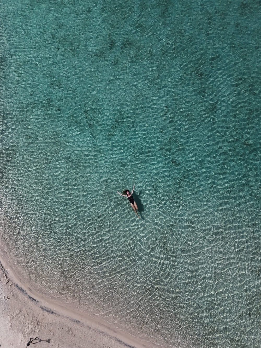 A person swims and relaxes in the crystal-clear waters of a lagoon in Lençóis Maranhenses. A person swims and relaxes in the crystal-clear waters of a lagoon in Lençóis Maranhenses.