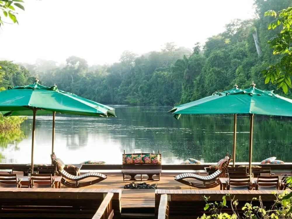 Lounge chairs and green umbrellas on the floating deck at Cristalino Lodge, an amazing Amazon eco lodge in Brazil. Lounge chairs and green umbrellas on the floating deck at Cristalino Lodge, an amazing Amazon eco lodge in Brazil.