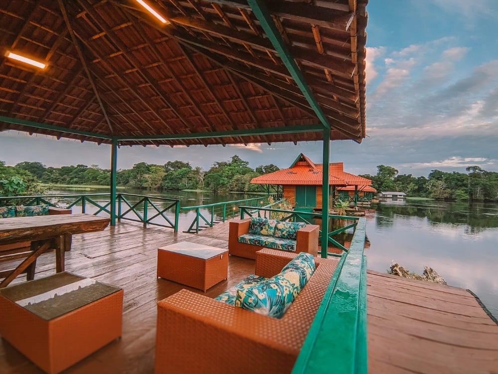 A wooden deck with comfortable sofas overlooking the floating bungalows and river at Uakari Lodge in Brazil. A wooden deck with comfortable sofas overlooking the floating bungalows and river at Uakari Lodge in Brazil.
