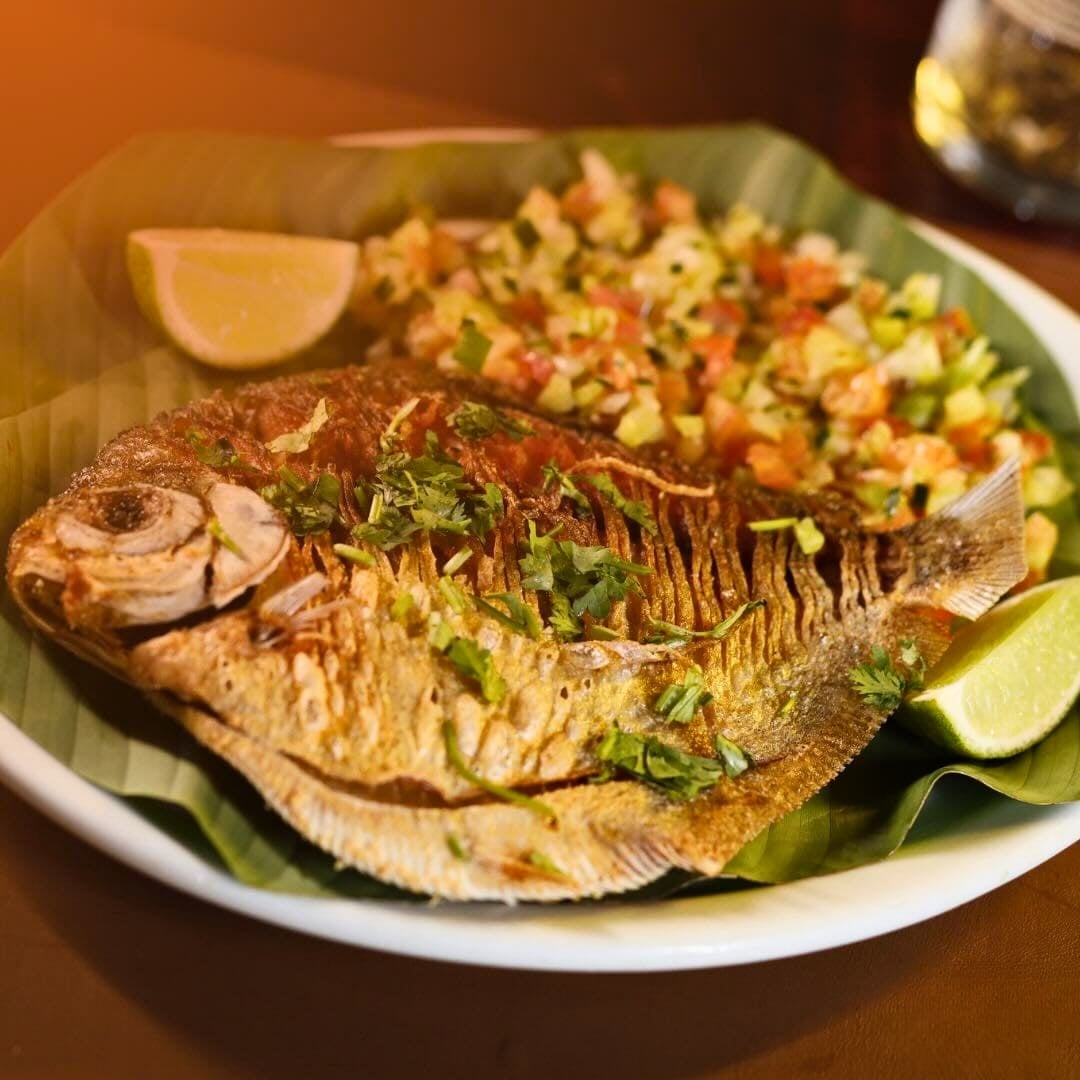Grilled Tambaqui fish served whole on a banana leaf with vinaigrette and lime slices. Grilled Tambaqui fish served whole on a banana leaf with vinaigrette and lime slices.
