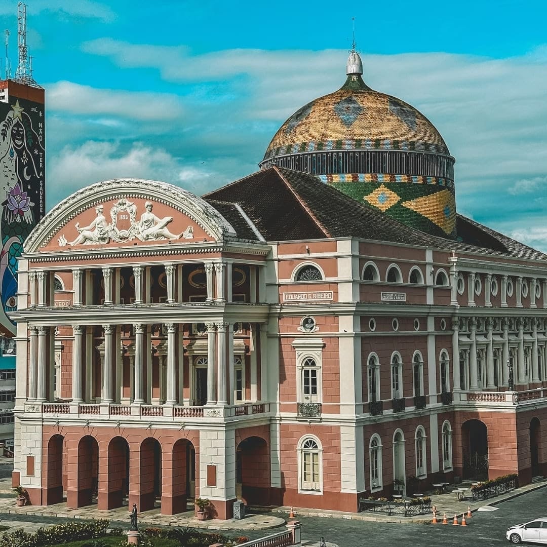 The historic Teatro Amazonas opera house in Manaus, featuring a tiled dome and pink facade, serving as the gateway to the Amazon. The historic Teatro Amazonas opera house in Manaus, featuring a tiled dome and pink facade, serving as the gateway to the Amazon.