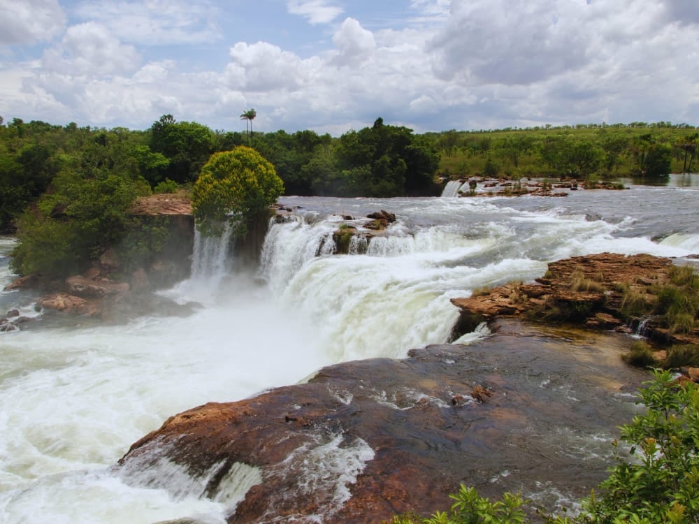 The powerful horseshoe-shaped Velha Waterfall cascading over rocky cliffs along the well-preserved Novo River The powerful horseshoe-shaped Velha Waterfall cascading over rocky cliffs along the well-preserved Novo River