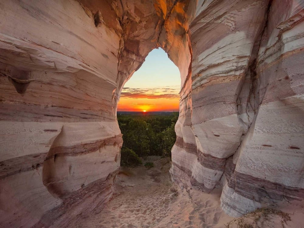 A bright sunset viewed through a natural sandstone wall, highlighting the consistently sunny weather in northern Brazil A bright sunset viewed through a natural sandstone wall, highlighting the consistently sunny weather in northern Brazil