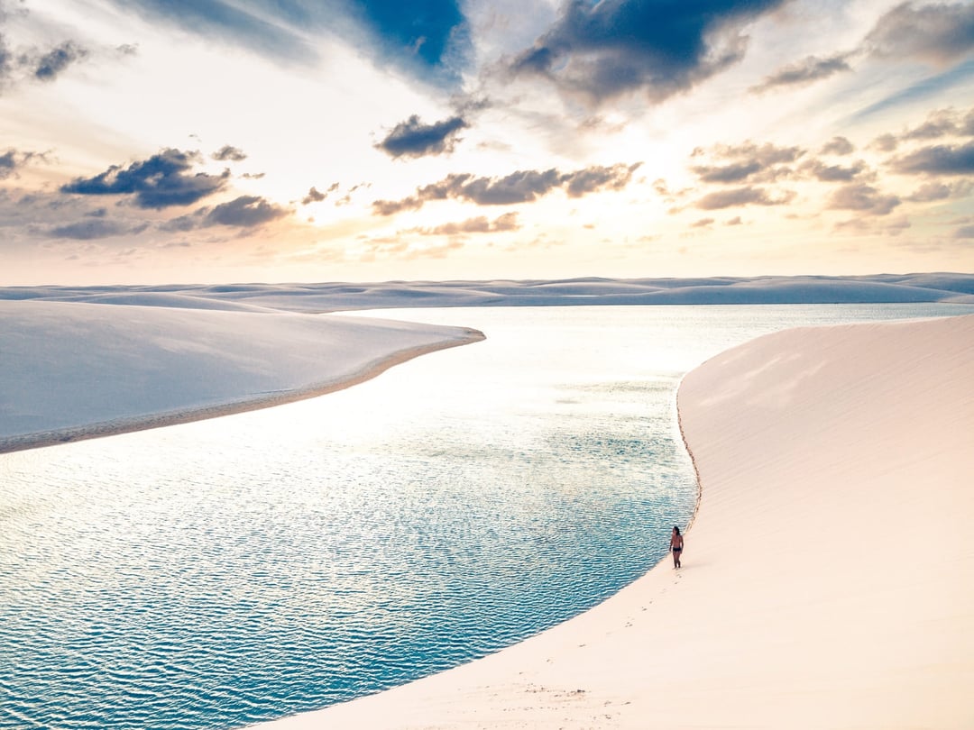 Hikers cross the dunes and freshwater lagoons of Lençóis Maranhenses in Brazil Hikers cross the dunes and freshwater lagoons of Lençóis Maranhenses in Brazil