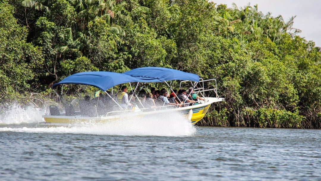 Passengers ride a yellow motorboat with blue canopies along the Preguiças River on their way to Atins. Passengers ride a yellow motorboat with blue canopies along the Preguiças River on their way to Atins.