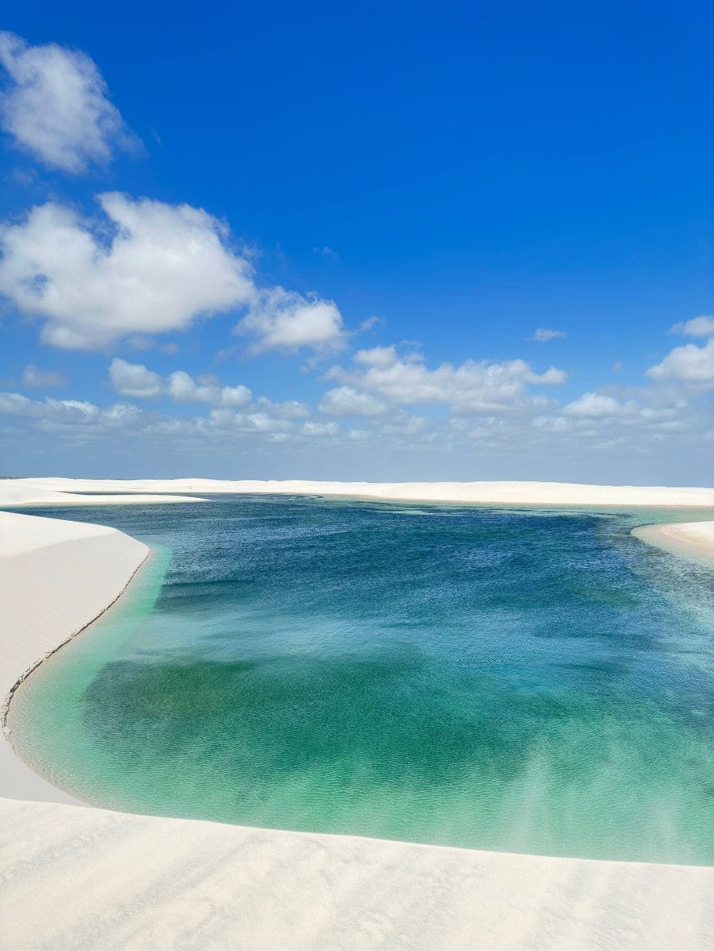 A pristine turquoise lagoon rests between the expansive white sand dunes near Barreirinhas. A pristine turquoise lagoon rests between the expansive white sand dunes near Barreirinhas.