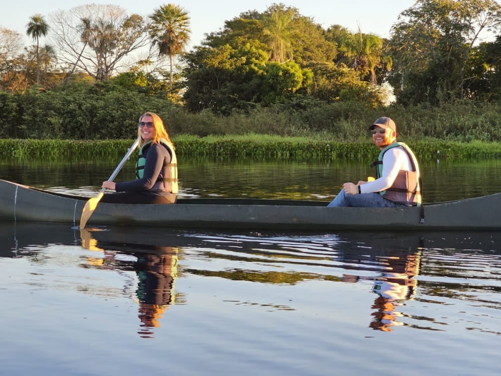 Two travelers paddling a canoe through calm waters, an immersive way to explore the wetlands during a Pantanal tour. Two travelers paddling a canoe through calm waters, an immersive way to explore the wetlands during a Pantanal tour.