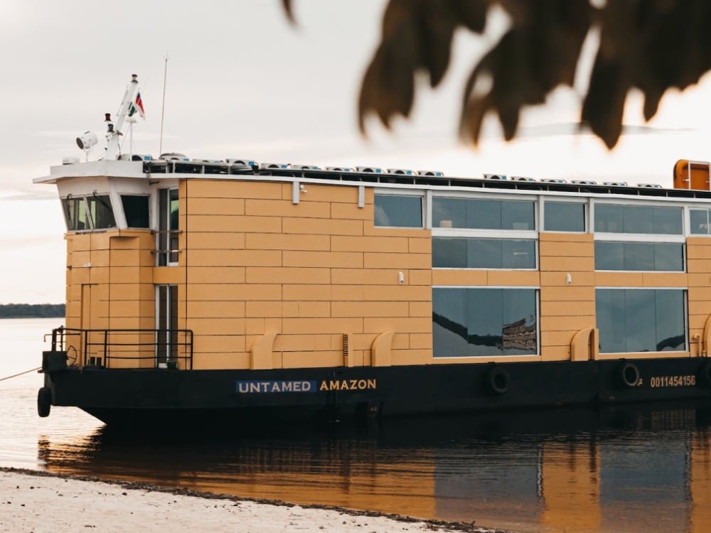 The Untamed Amazon riverboat featuring a modern design with a yellow hull, known for being a sustainable solar-powered cruise option. The Untamed Amazon riverboat featuring a modern design with a yellow hull, known for being a sustainable solar-powered cruise option.