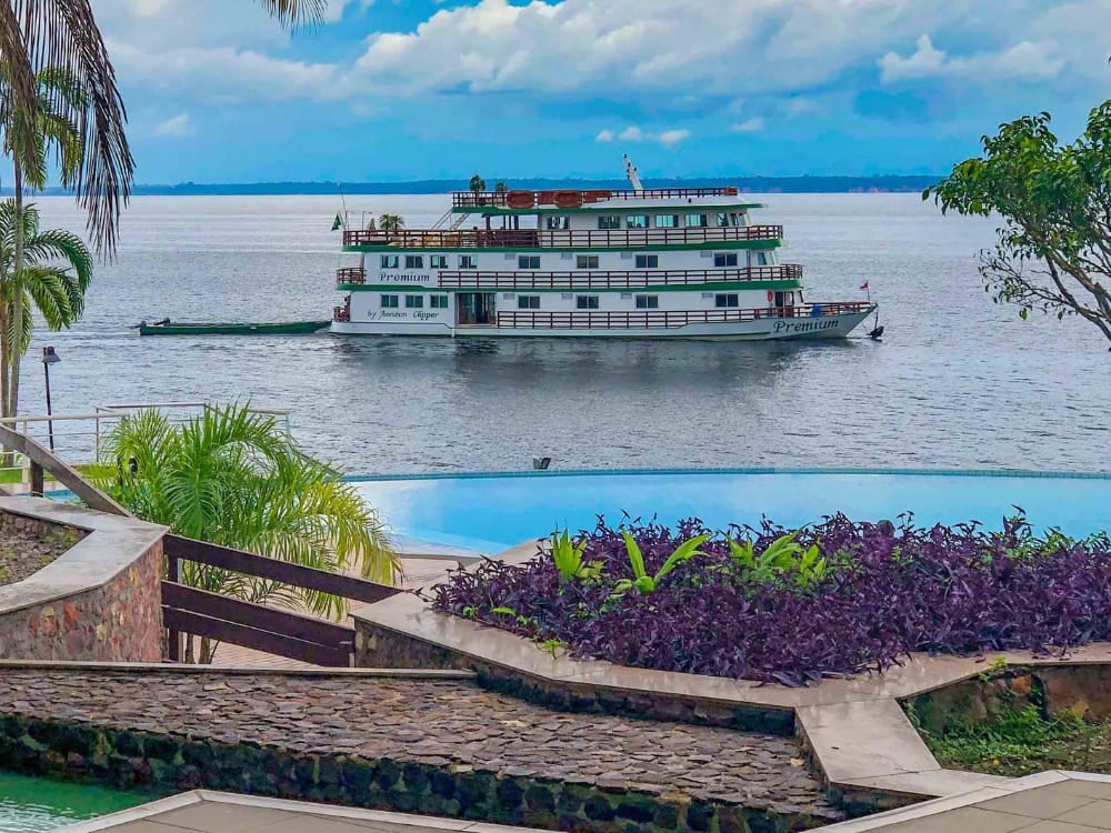 The Amazon Clipper Premium vessel docked near a riverside pool, offering a luxurious small-ship experience in the Amazon. The Amazon Clipper Premium vessel docked near a riverside pool, offering a luxurious small-ship experience in the Amazon.