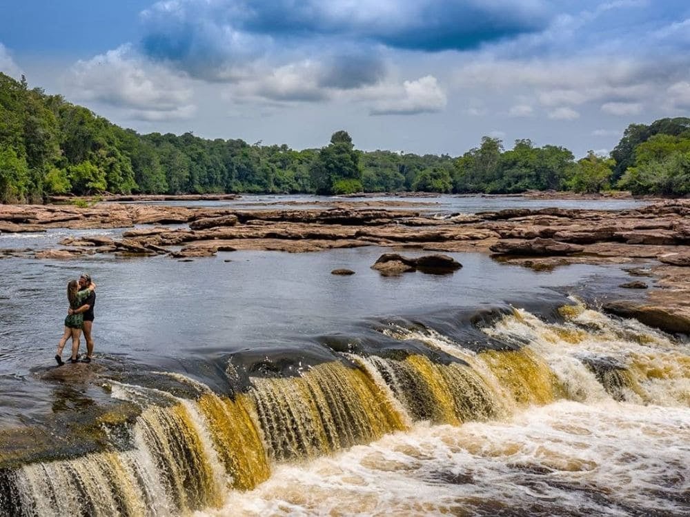 Couple hugging in the shallow waters of river rapids surrounded by forest in the Jaú National Park. Couple hugging in the shallow waters of river rapids surrounded by forest in the Jaú National Park.