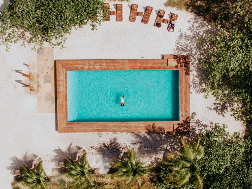 Aerial view of a person swimming in a rectangular pool at La Ferme de Georges inn. Aerial view of a person swimming in a rectangular pool at La Ferme de Georges inn.