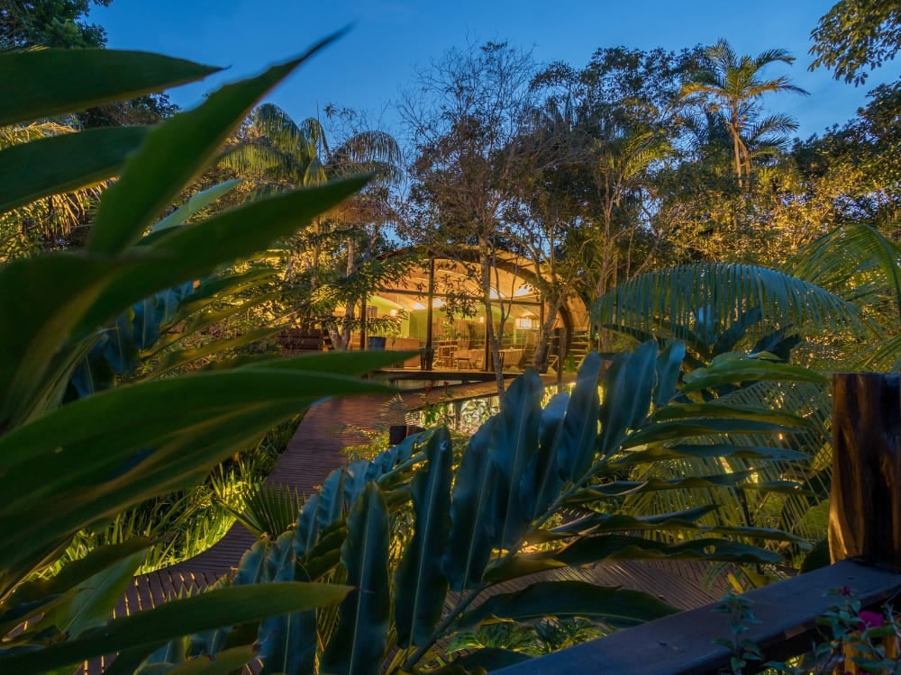 Illuminated wooden bungalow at Mirante do Gaviao Amazon Lodge surrounded by trees at night. Illuminated wooden bungalow at Mirante do Gaviao Amazon Lodge surrounded by trees at night.