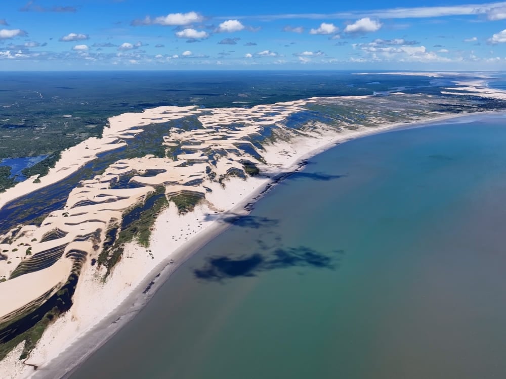 Aerial perspective of the Delta do Parnaiba showing the river branching into the ocean alongside large coastal sand dunes. Aerial perspective of the Delta do Parnaiba showing the river branching into the ocean alongside large coastal sand dunes.