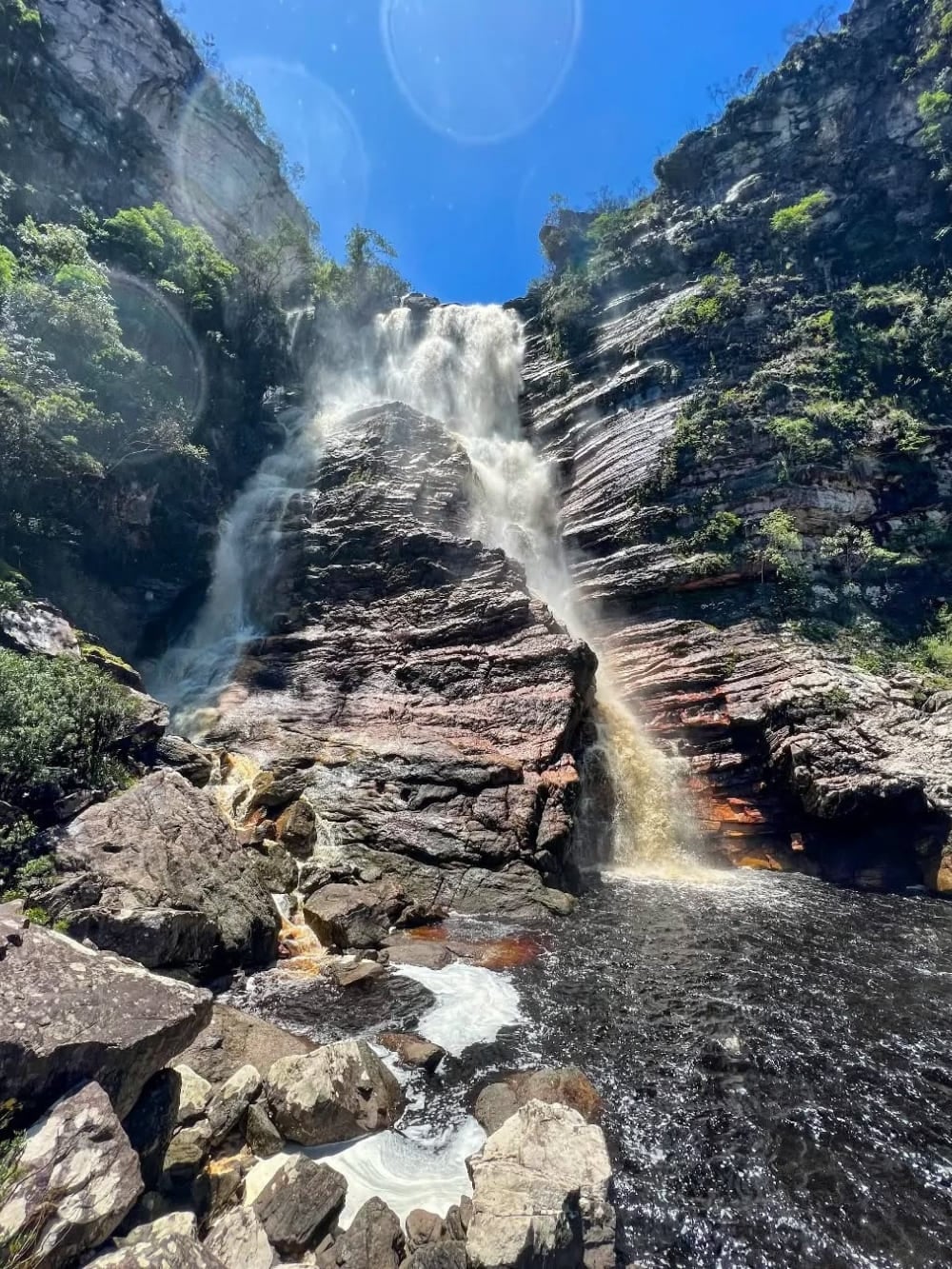 The tall Samuel Waterfall cascades down massive rocky walls into a dark pool, surrounded by lush forest near Andaraí. The tall Samuel Waterfall cascades down massive rocky walls into a dark pool, surrounded by lush forest near Andaraí.