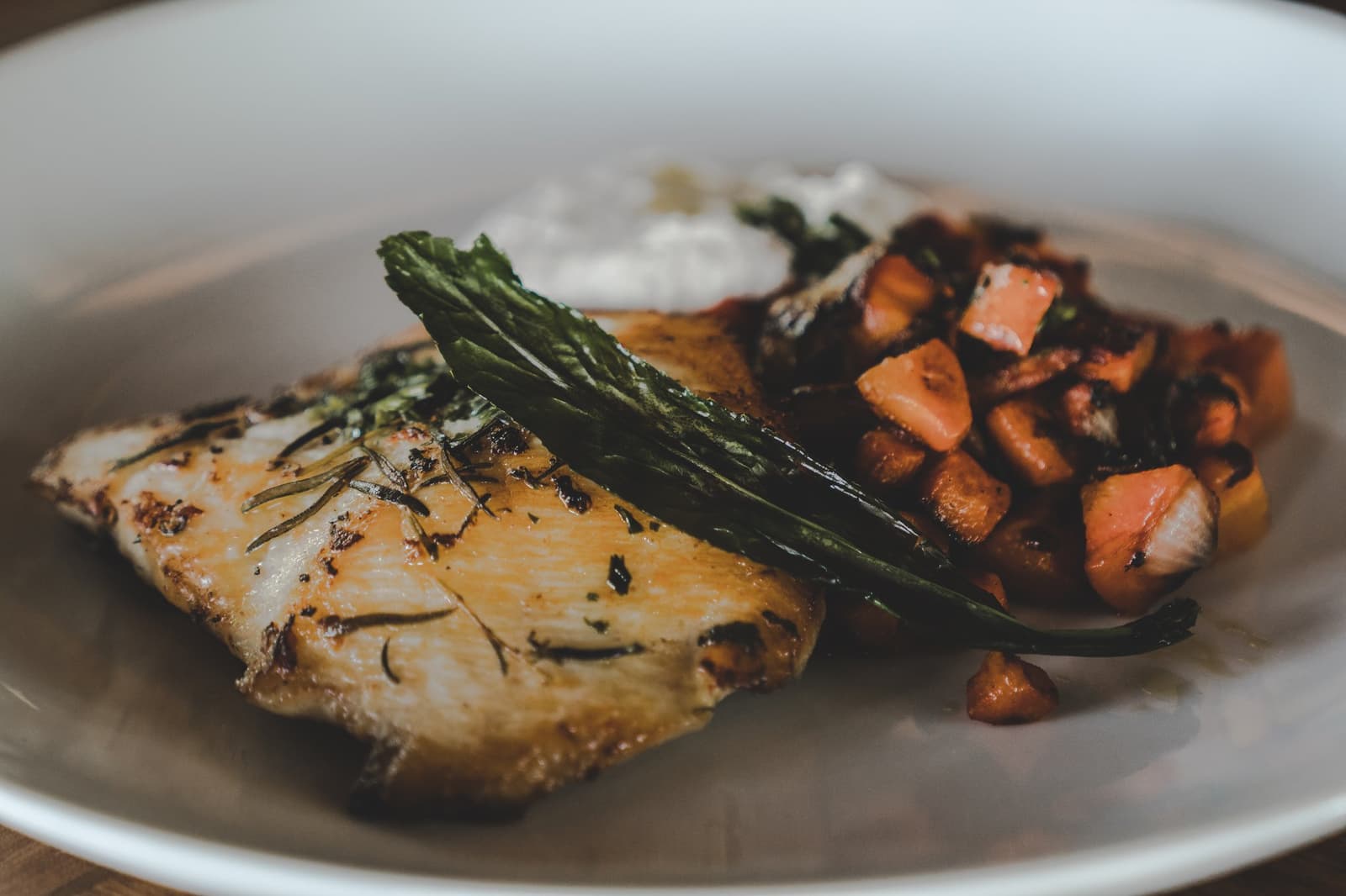 Simple ingredients, serious cooking, the lodge kitchen earns its keep. A herb-crusted grilled fish fillet served with sautéed diced sweet potato and wilted greens at Mirante do Gavião's on-site restaurant