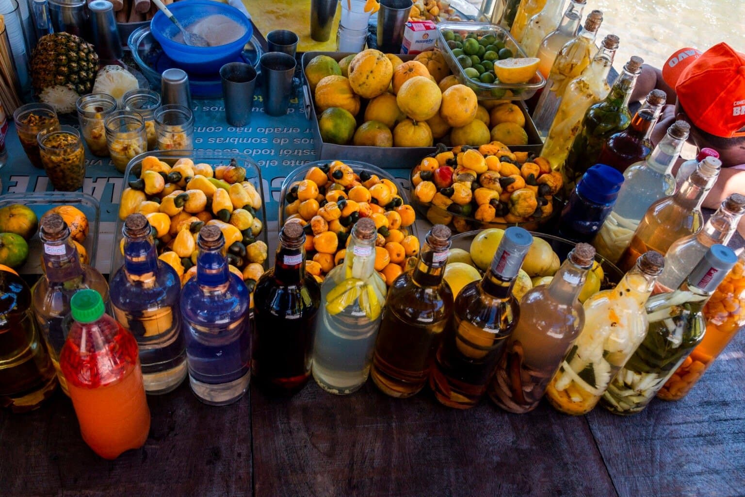 Pick a bottle, any bottle. The locals have been perfecting these recipes for a long time. A market stall loaded with trays of fresh cashew fruit and tropical citrus alongside rows of colourful homemade infused liqueur bottles, part of the local food culture along the Lençóis Maranhenses full itinerary