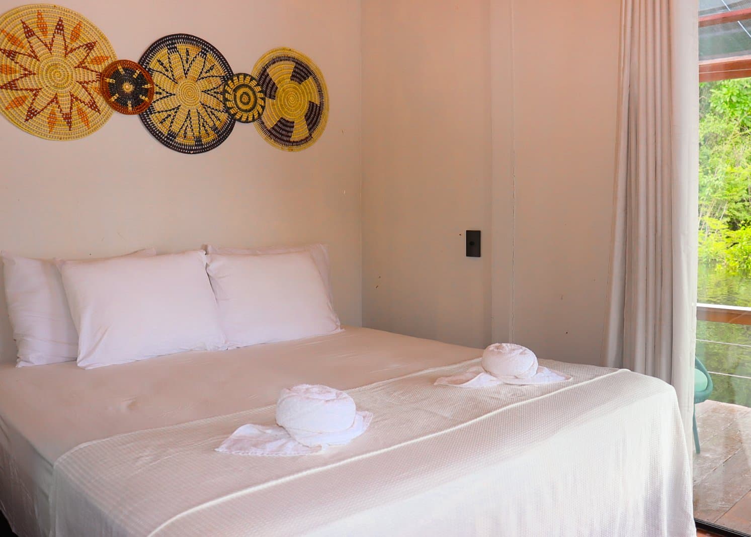 Handcrafted basket art, crisp white linens, and the green canopy just beyond the window. Photo 6