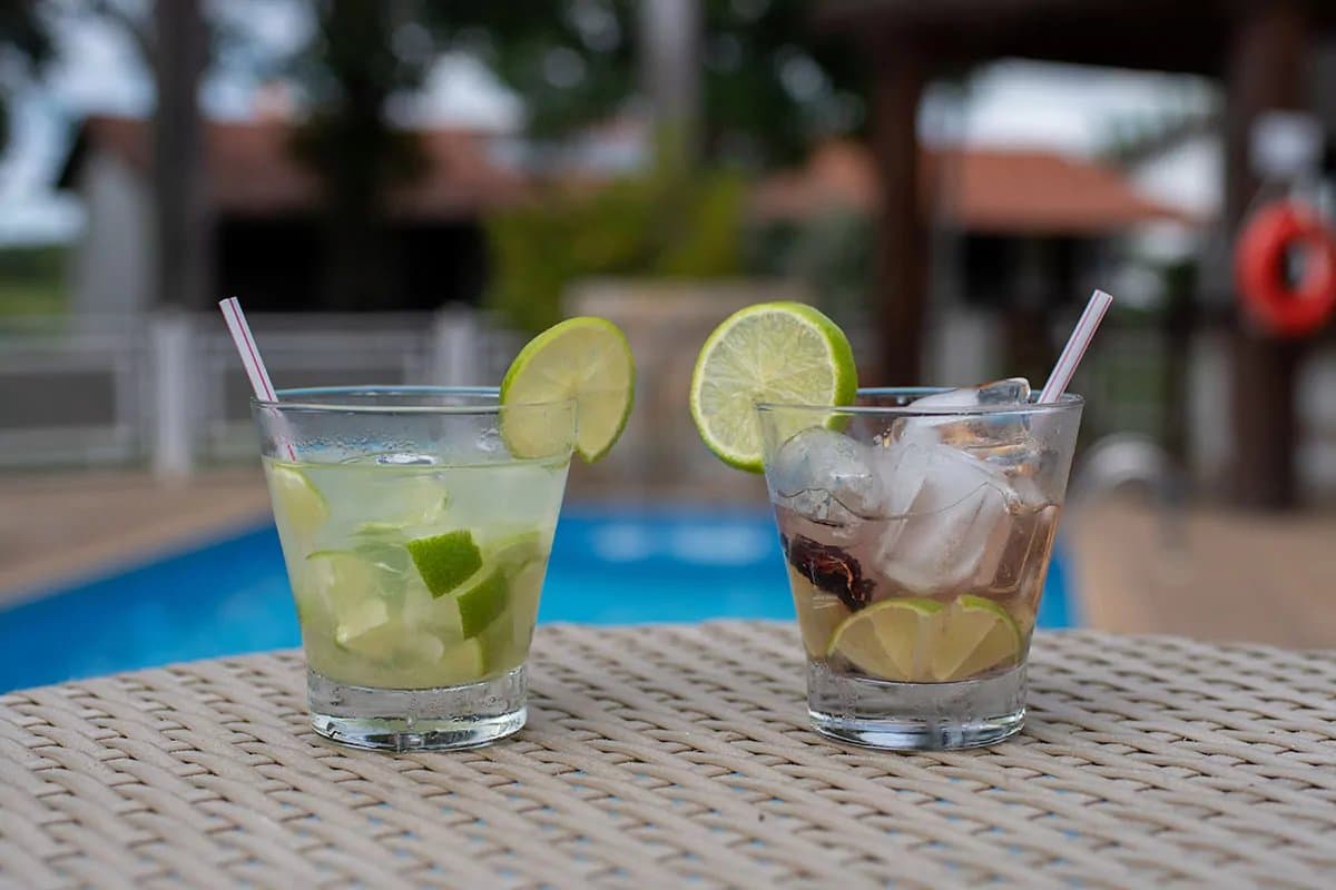 The best part of the afternoon sorted, right there. Two lime-garnished cocktails on a wicker table beside a swimming pool, served during a Pantanal Bonito tour lodge stay