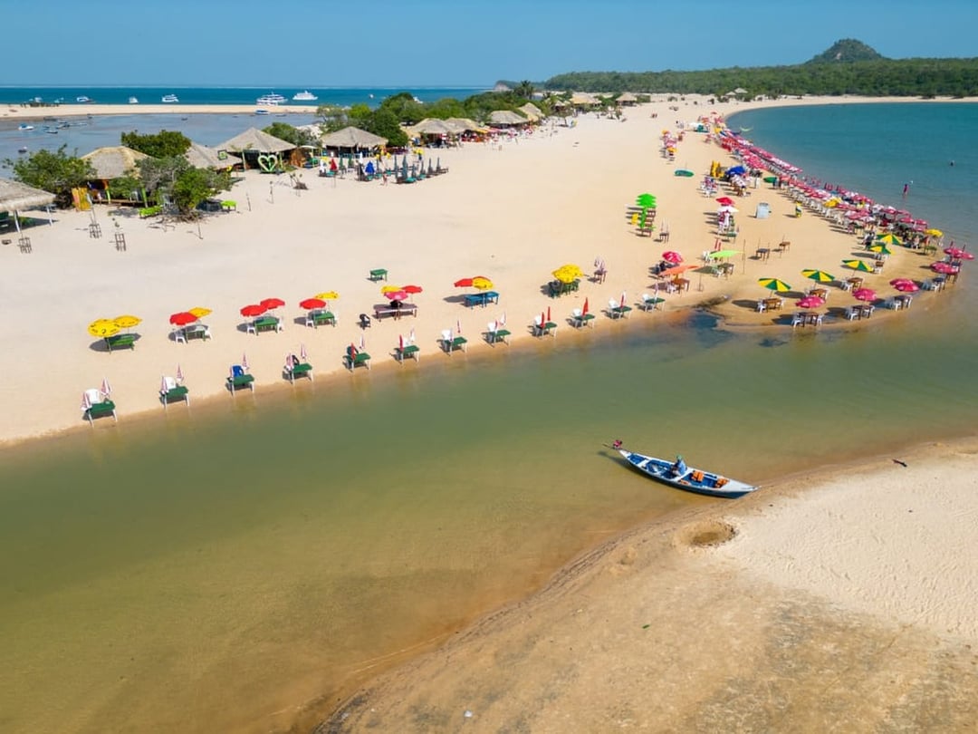 Aerial view of an Amazon river beach with colorful umbrellas and tables on white sand Aerial view of an Amazon river beach with colorful umbrellas and tables on white sand