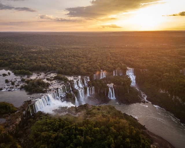 Aerial view of Iguazu Falls at sunset, with dozens of cascades cutting across the Atlantic Forest, Brazil. Aerial view of Iguazu Falls at sunset, with dozens of cascades cutting across the Atlantic Forest, Brazil.