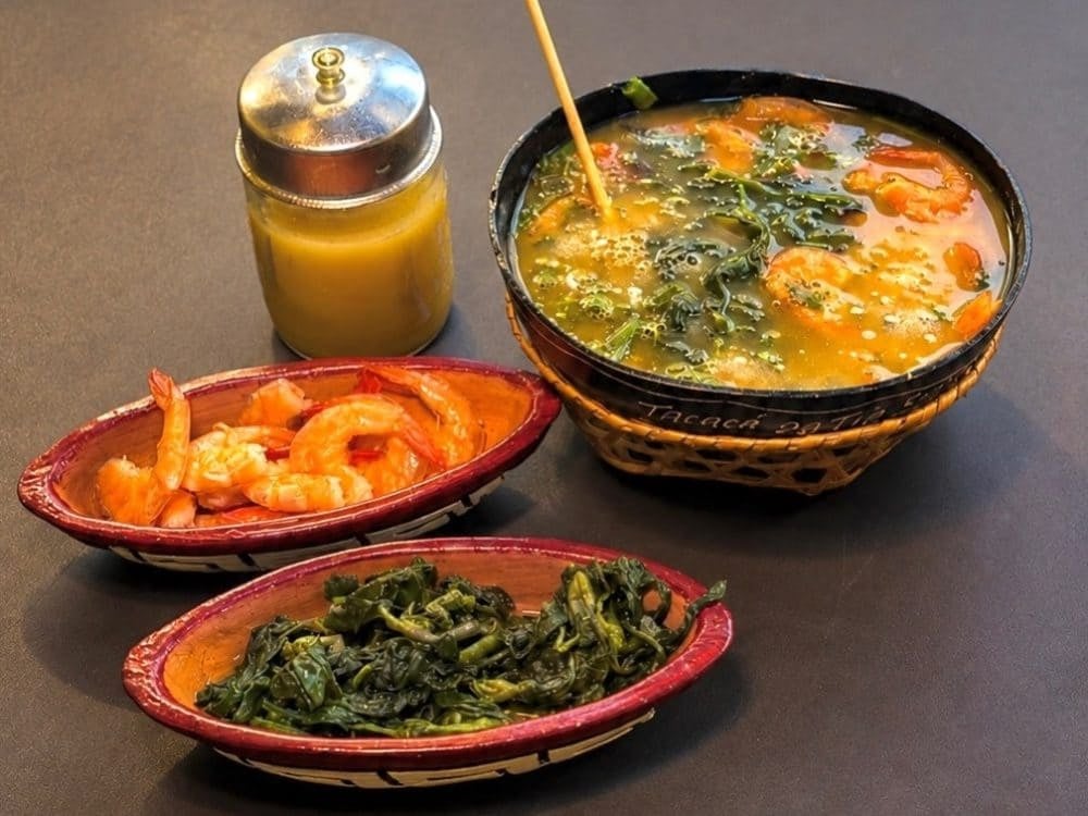 @tacacadatiasocorro A cuia of tacacá with jambu and dried shrimp, beside bowls of shrimp, jambu and a jar of tucupi