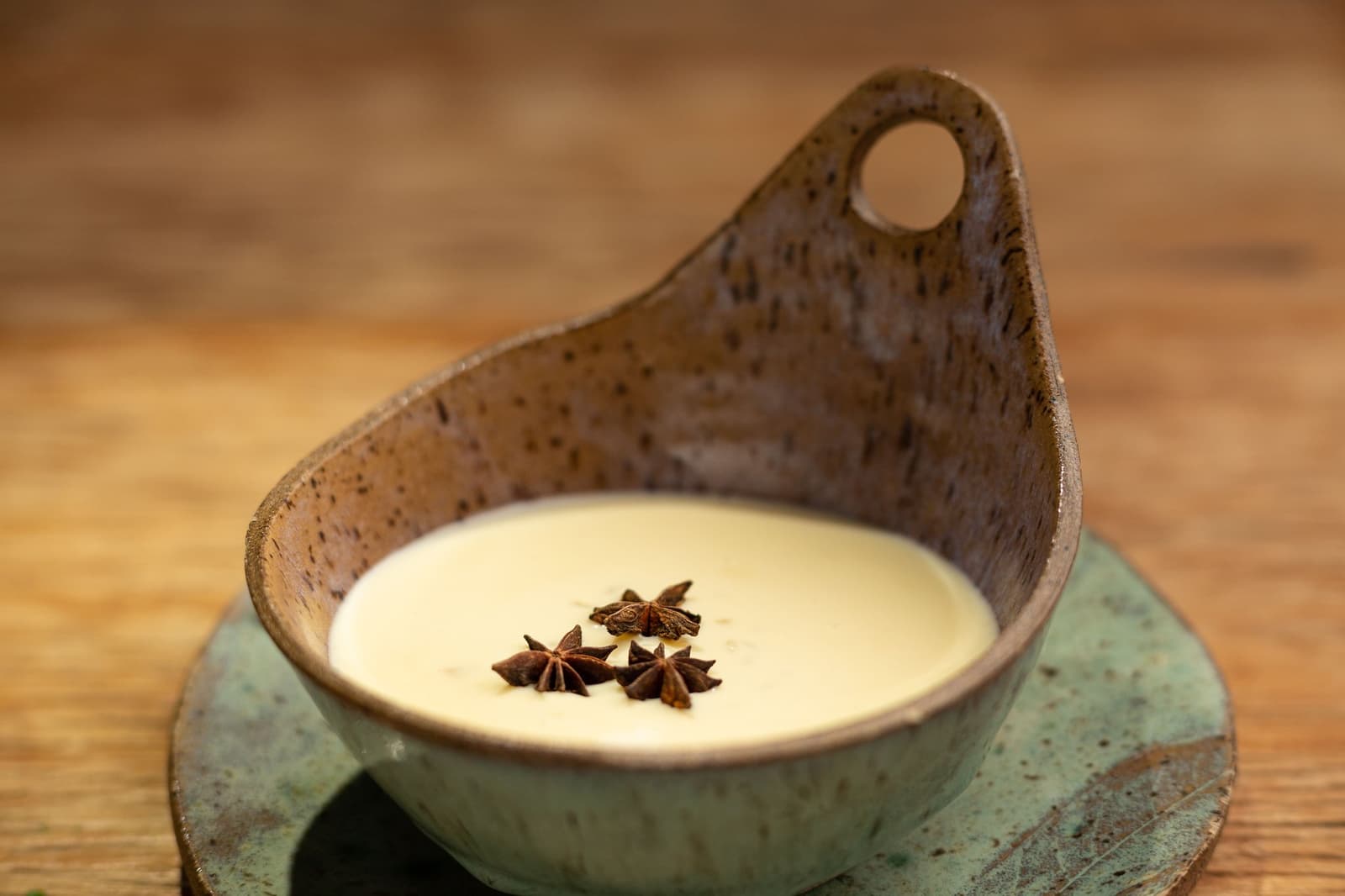 Local ingredients, chef-level intentions, eaten slowly. A smooth cream dessert garnished with three star anise pods, served in a rustic handmade ceramic bowl at the Ibiti Project